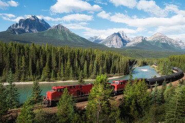 Red cargo train passing through Morant's curve in Bow Valley, Banff National Park, Alberta, Canada....