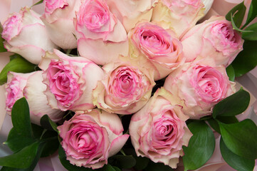 Fototapeta na wymiar bouquet of pink white roses with leaves in packaging. mother's day, valentine's day, womens day