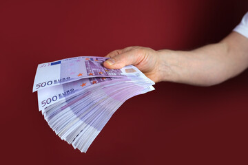 male hands hold paper 500 euro banknotes in his hands, counting a bundle of money, concept of cash,...