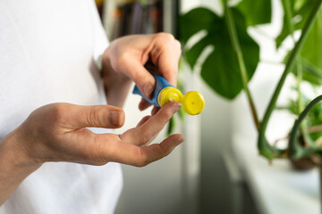 Woman applying moisturizing nourishing balm to her finger to prevent dryness and chapping her lips in the cold season, close up. Lip protection.