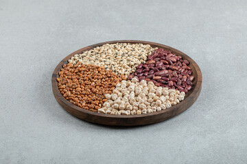 Plate of various dry pea and beans on marble surface