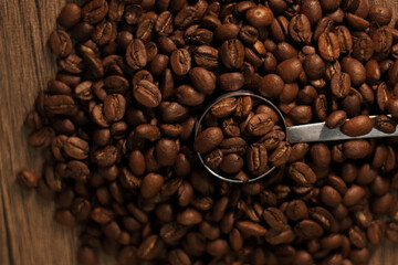 cuchara medidora de café esta cubierta por multiples granos de café 
