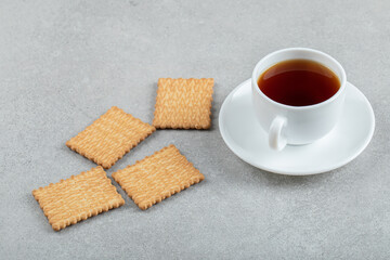 Aroma cup of tea with tasty crackers on a wooden table