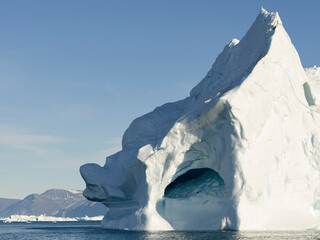 Iceberg in the Uummannaq Fjord System. Glaciated Nuussuaq peninsula in the background. Greenland,...