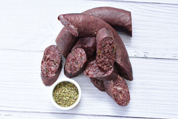 Morcilla Antioqueña, traditional Colombian sausage, covered with lemon and pepper on wooden background