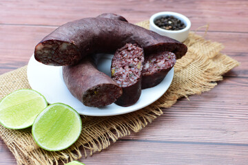 Morcilla Antioqueña, traditional Colombian sausage, covered with lemon and pepper on wooden...