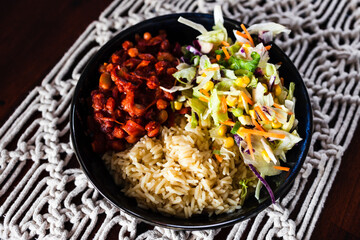 healthy plant-based food, vegan nourish bowl with bean chilli sauce, rice and Mexican coleslaw salad mix