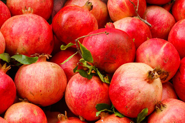 Heap of fresh pomegranates for sale in market. Background of pomegranate fruits