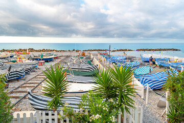 Morning view of a colorful boat marina on the pebble beach of Ventimiglia, Italy, along the Italian Riviera.