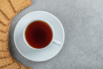 Aroma cup of tea with tasty crackers on a wooden table