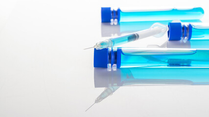 Vaccination bottle. Medical syringe with needle for protection flu virus and coronavirus. Covid vaccine on white. Concept: diseases, medical care, science.