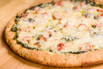 Freshly-baked, vegetarian, pesto, multi-grain, thick-crust pizza.