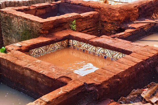 Different old stone vats with red dye for leather at Tannery of Tetouan Medina. Northern Morocco.