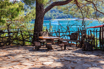 Empty rustic round wooden table and stools in park  in Kemer, Turkey