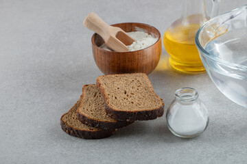 Slices of brown bread with woden bowl of flour