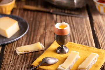 boiled egg in a silver eggcup with bread