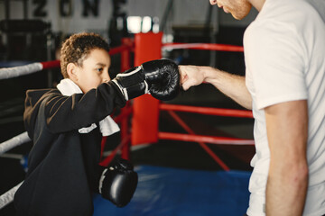 Fototapeta na wymiar Young hardworking boxer learning to box. Child at sport center. Kid taking up a new hobby
