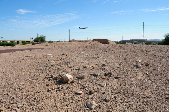 Vacant lot near city airport and airplane approaching landing