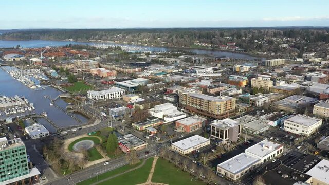 Cinematic panning drone bird's-eye footage of the Port of Olympia, commercial and residential areas, stores and businesses downtown, in the historic district of Olympia, Pierce County, Washington