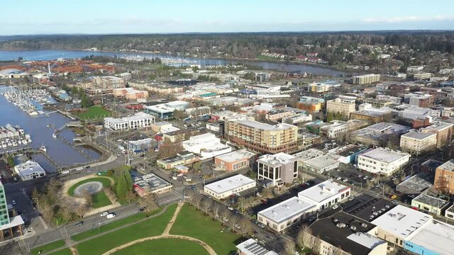 Cinematic aerial drone dolly bird's-eye shot of the Port of Olympia, commercial and residential areas, stores and businesses downtown, in the historic district of Olympia, Pierce County, Washington