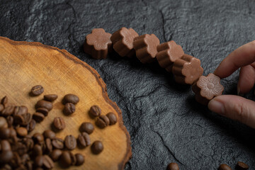 Hand taking chocolate candies on a dark background