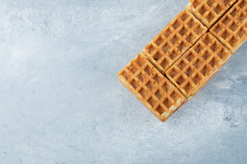 Delicious fresh waffles on a gray background