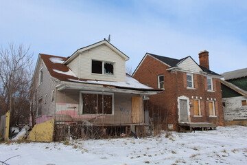 Fototapeta na wymiar Two abandoned Frankin Park homes in Detroit in winter
