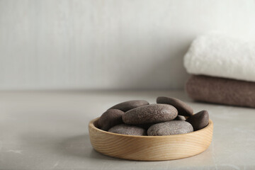 Spa stones in wooden tray on light table