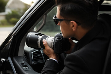 Private detective with camera spying from car