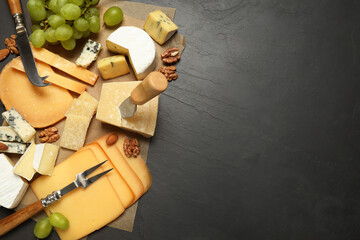 Flat lay composition with different sorts of cheese and knives on black table. Space for text
