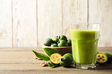 Fresh feijoa smoothie and fresh fruits on wooden table, closeup. Space for text
