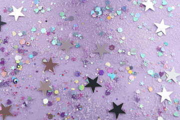 Shiny glitter on lilac background, flat lay