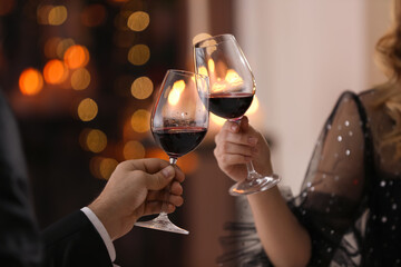 Couple clinking glasses at Valentine's day dinner in restaurant, closeup