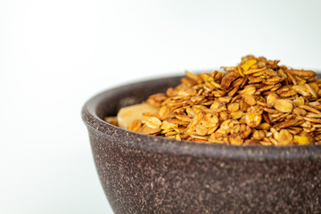 GRANOLA EM TIGELA DE MADEIRA EM FUNDO BRANCO