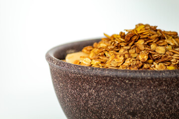 GRANOLA EM TIGELA DE MADEIRA EM FUNDO BRANCO