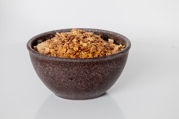 GRANOLA EM TIGELA DE MADEIRA EM FUNDO BRANCO