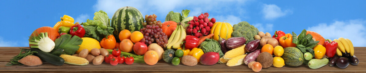 Assortment of fresh organic fruits and vegetables on wooden table outdoors. Banner design