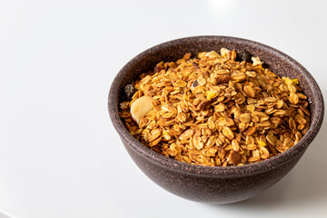 GRANOLA EM TIGELA DE MADEIRA EM FUNDO BRANCO