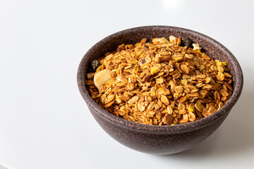 GRANOLA EM TIGELA DE MADEIRA EM FUNDO BRANCO
