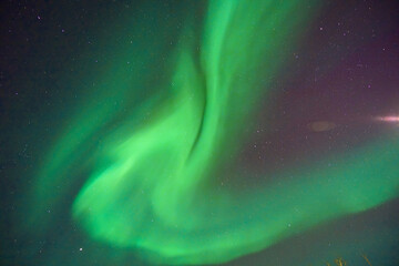 Aurora borealis in the night sky. The light colors are green, yellow, and red. Photographed in Alaska, the USA on March 17, 2016
