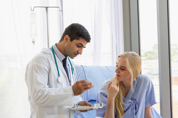 male doctor examines the symptoms of a woman's patient in the bed and talks about his illness