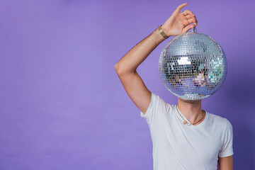 Man holding a mirror ball as a head on a purple background
