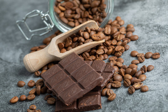 Chocolate bar with a wooden spoon of coffee beans