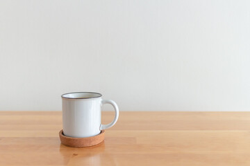 White cup of hot coffee mug on wooden table with isolate white background.