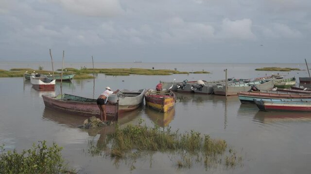 Fisherman preparing fishing boats in marshland 