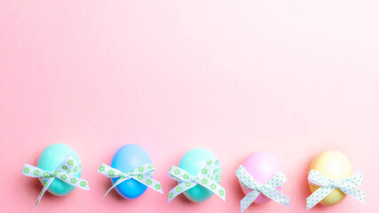 Easter background pink. Colourful egg with tape ribbon on pastel pink background in Happy Easter decoration. Flat lay, top view.
