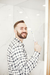 Man in a home bathroo. Health and well being teeth care and grooming, indoors.