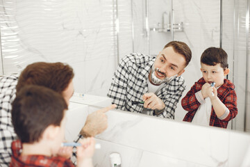 Father teaching his son to shave isolated. People with shaving foam in the bathroom.