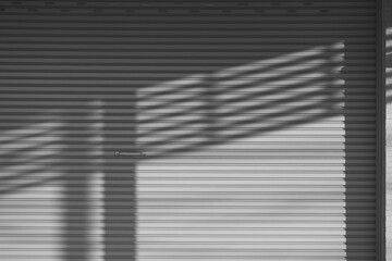 Sunlight and shadow on surface of roller shutter door background in black and white style