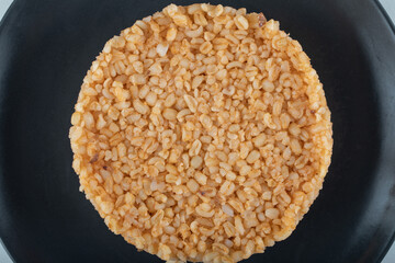 Turkish food bulgur rice on dark plate on a white background